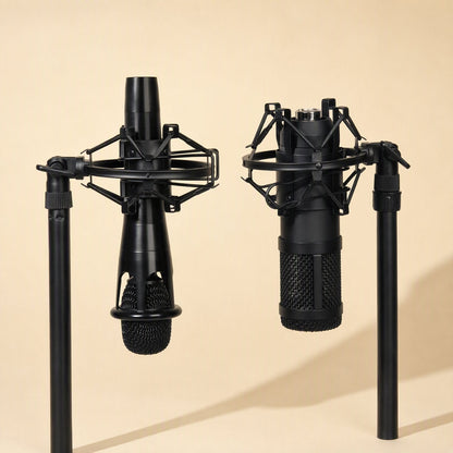 Joltcradle – Two black microphones suspended in shock mounts on boom arms, one slim and one with a mesh grille