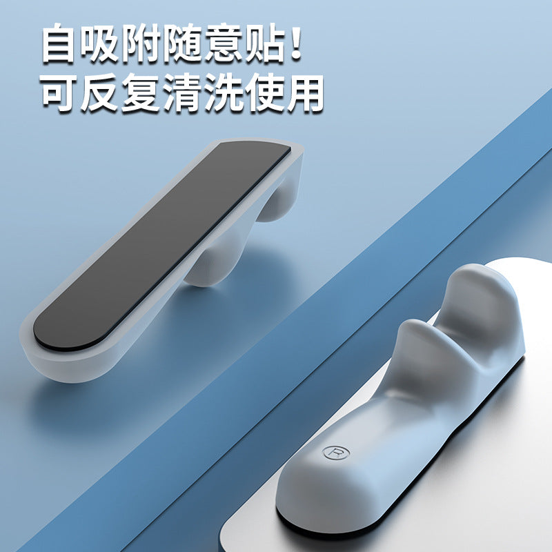 Tabletpalm – Two gray grips on a blue surface, one showing its black adhesive pad, the other stuck to a tablet
