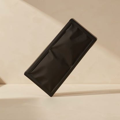 Dustmesh PVC magnetic dust filter in matte black, tilted upright against a warm beige wall