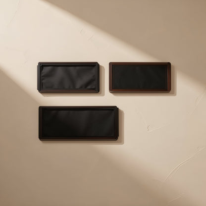 Dustmesh – Three black rectangular dust filters in different sizes arranged on a textured beige wall