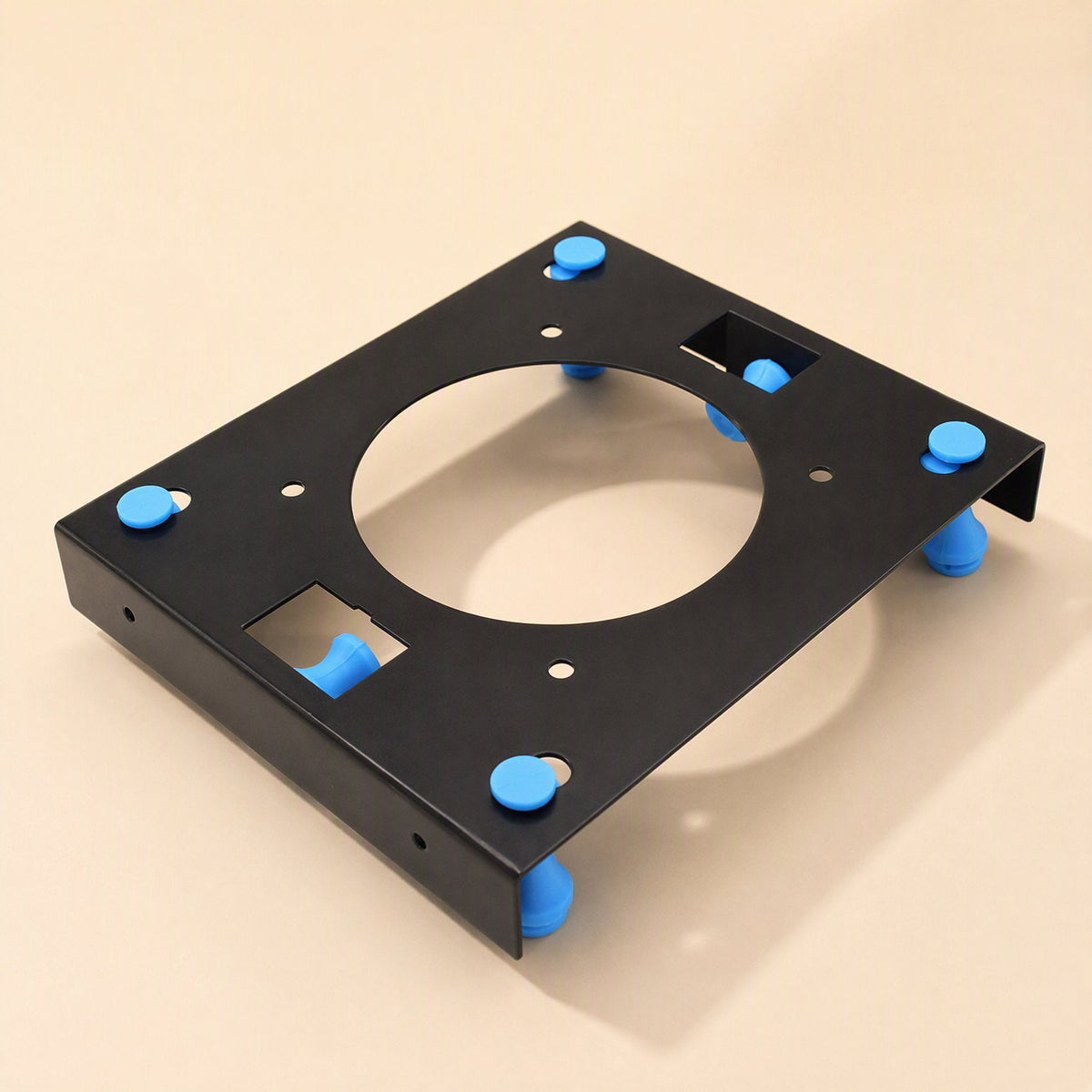 Rackshift – Top-down angled view of the black bracket showing the large round opening, screw holes and blue rubber pegs