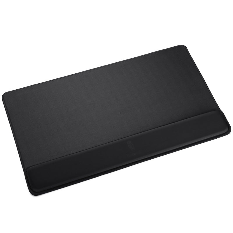 Padrest – Large black desk pad with attached wrist rest along the front edge, seen from above at an angle