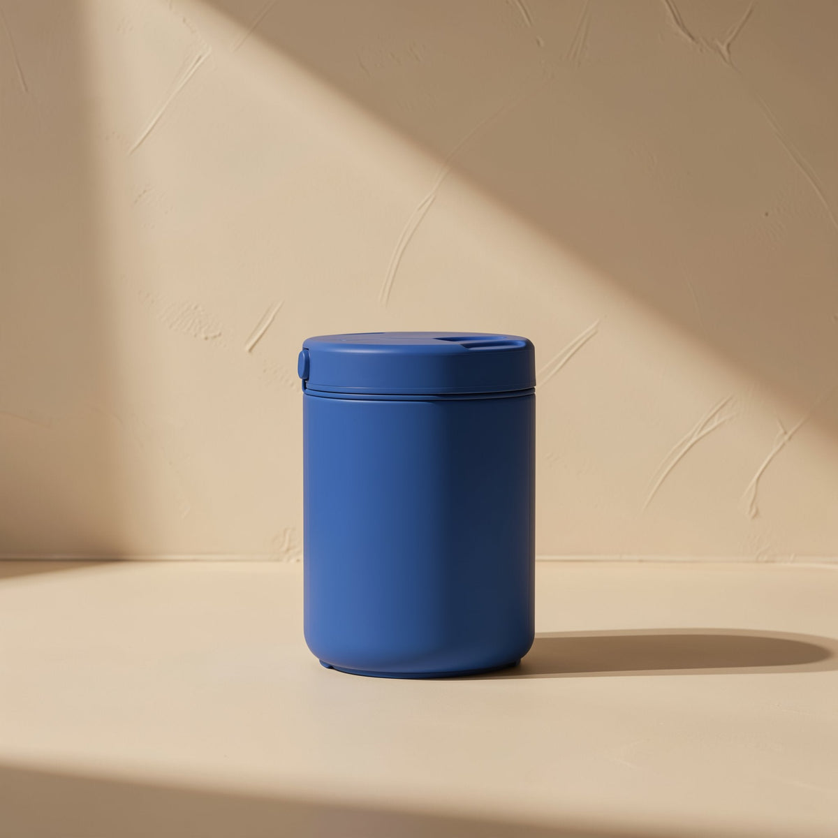 Bladechill 7-Blade PBT Cooling Fan – matte blue lidded container on a cream surface in angled sunlight, unrelated to the fan