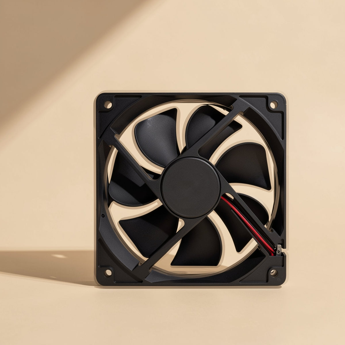Chillspin PBT computer cooling fan seen from the back, with spoke struts and red and black wires, on beige