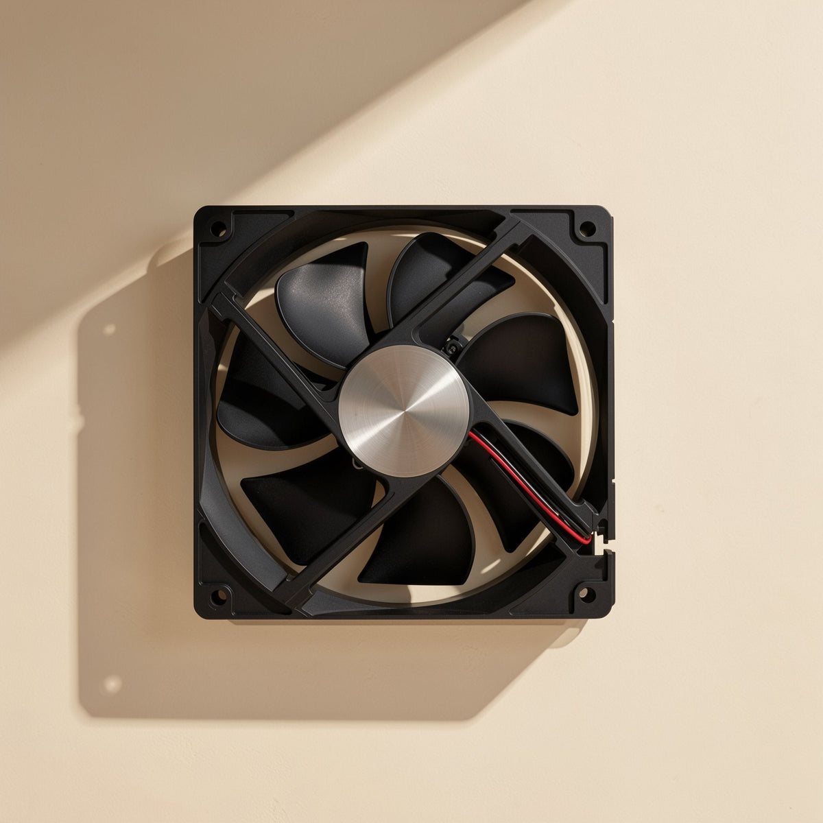 Chillspin – Angled rear view of the fan with a brushed metal hub and red and black wire leaving the frame, casting a shadow