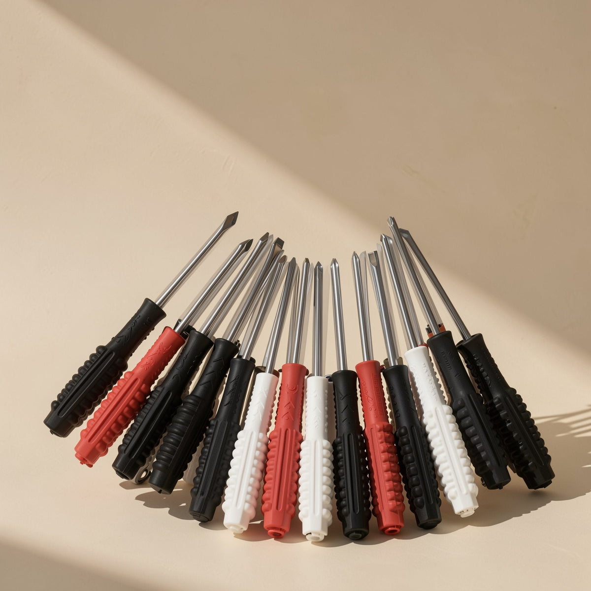 Screwbit – Row of screwdrivers with black, red and white textured handles fanned out, shafts pointing upward