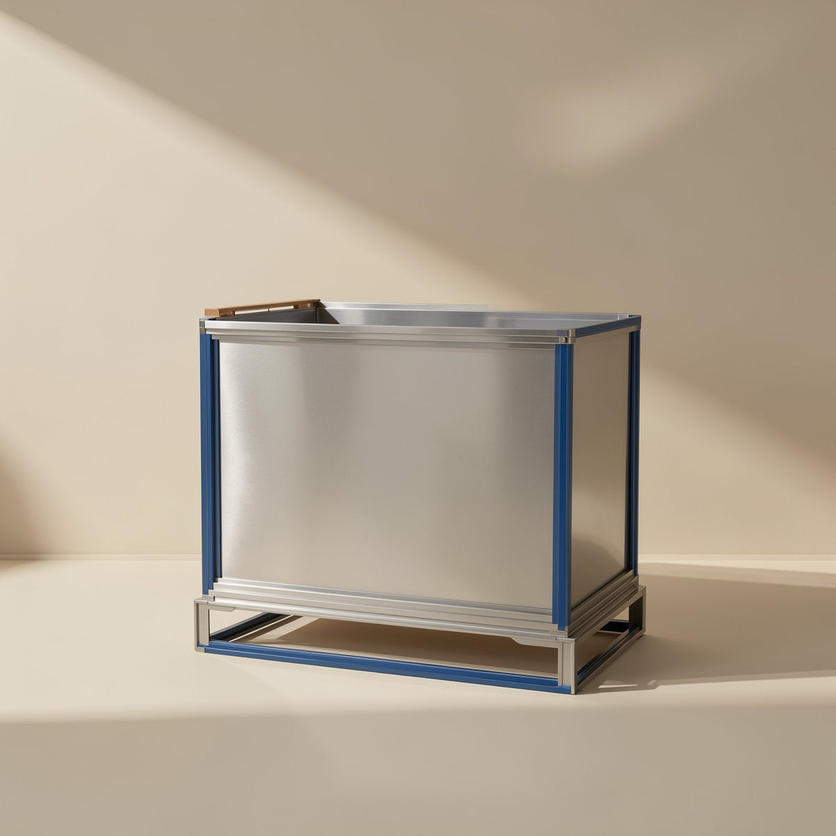 Gigabraid – Silver metal shipping container with blue frame edges on a low base, shown against a beige wall