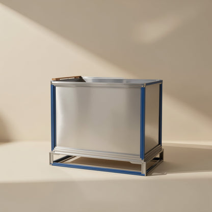 Gigabraid – Silver metal shipping container with blue frame edges on a low base, shown against a beige wall