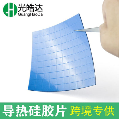 Gapflow – Hand using tweezers to peel a corner of a flexible blue thermal pad sheet divided into small squares