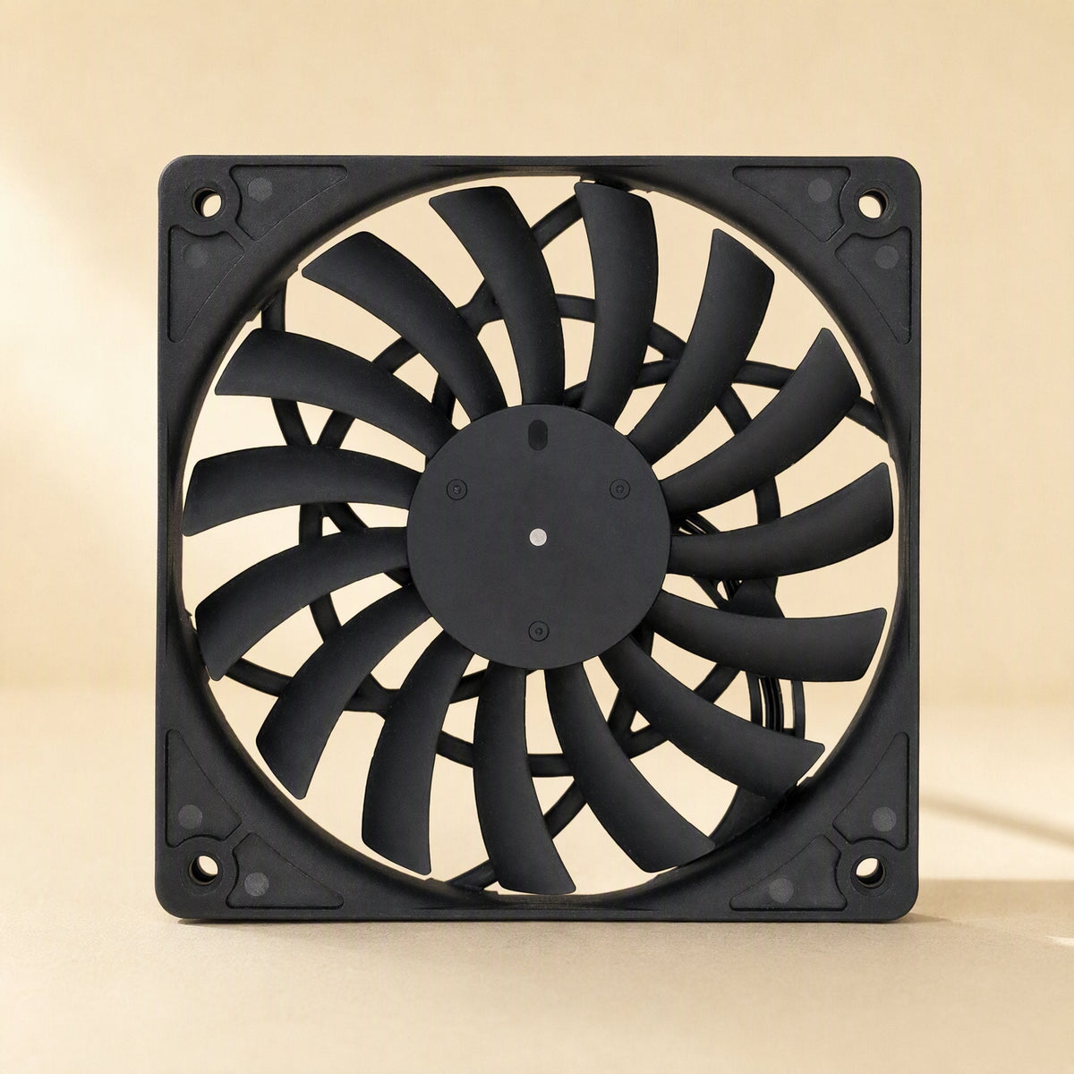 Airframe – Straight-on front view of the black fan with 4 corner mounting holes against a soft beige backdrop