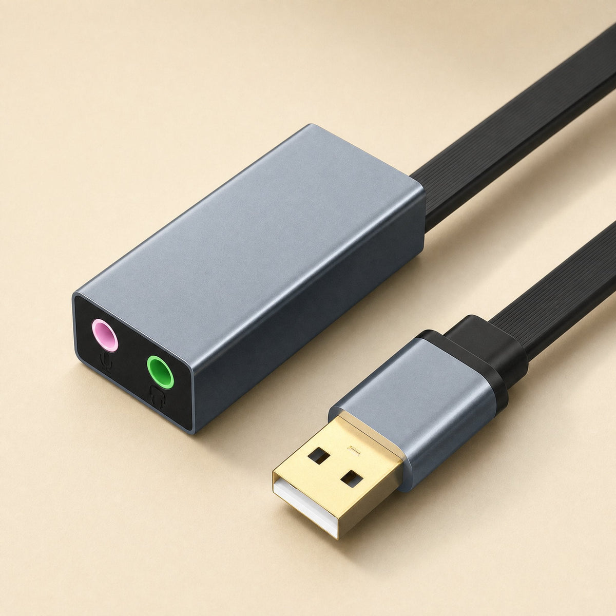 Twintone USB sound card, gray aluminum body with pink and green jacks, flat black cable and gold USB plug