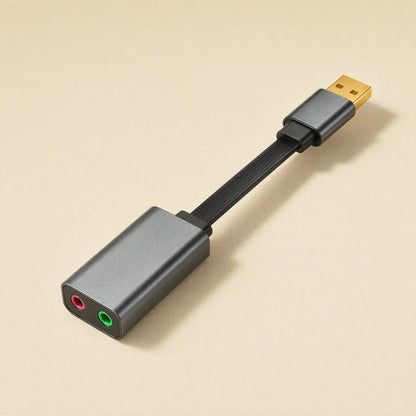 Twintone – Gray adapter on a short flat black cable, shown at an angle with pink and green jacks facing forward