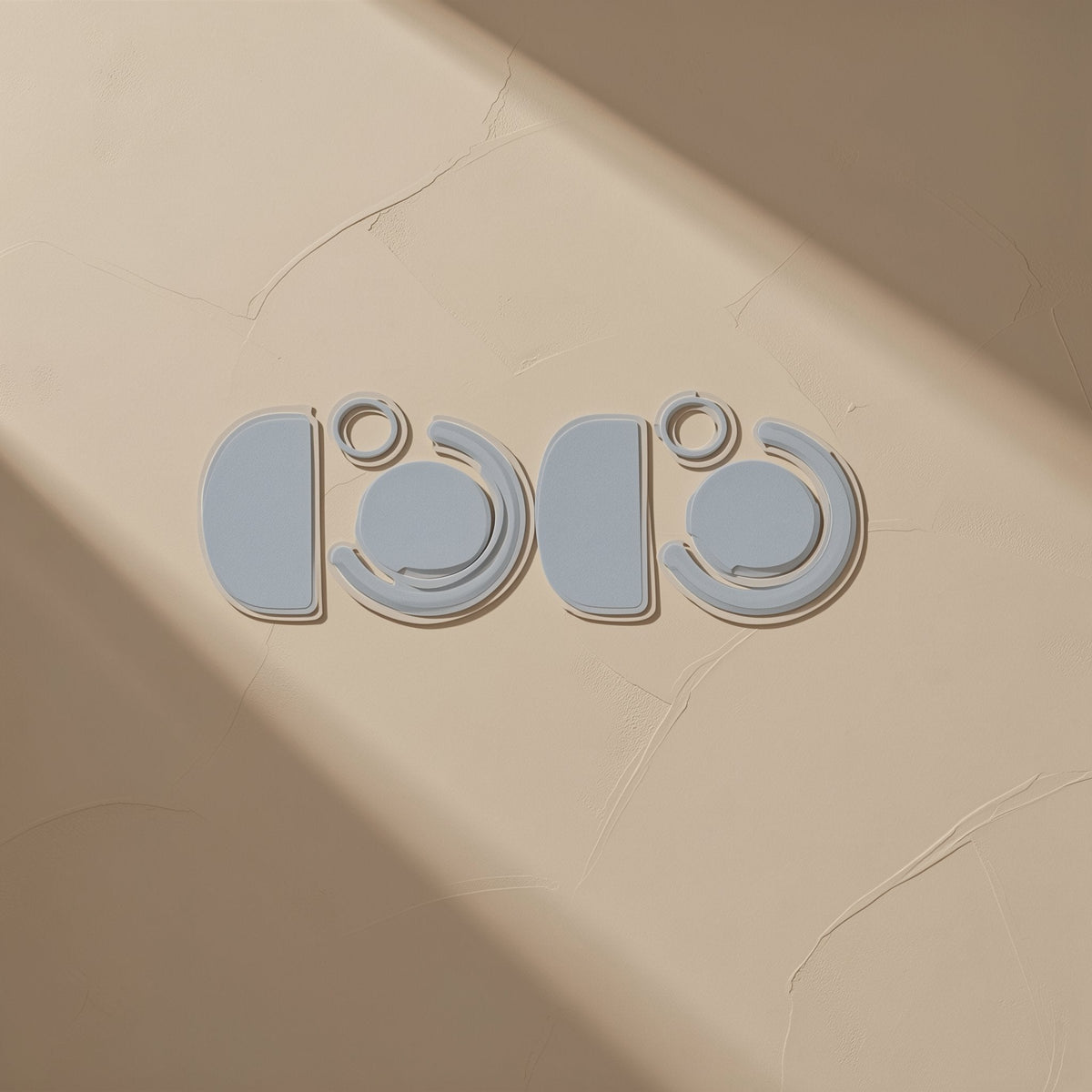 Glidefeet – Light blue-gray mouse feet in half-circle, ring and curved shapes, two matching sets on a textured beige wall