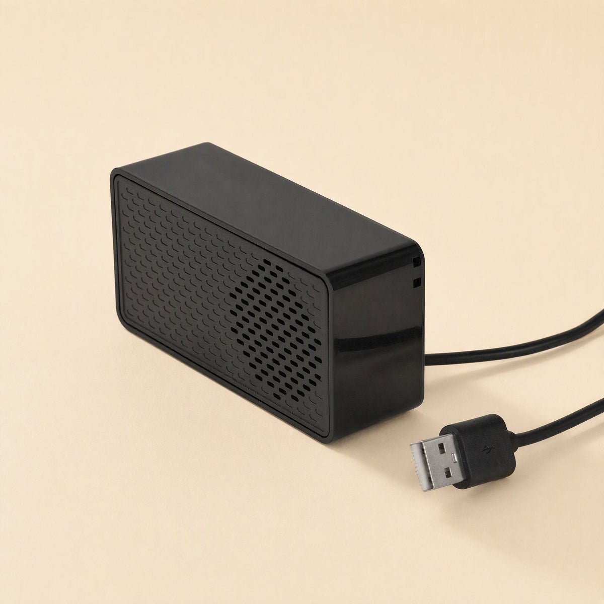 Soundport – Speaker seen from the side with a black cable trailing out and a USB plug in the foreground