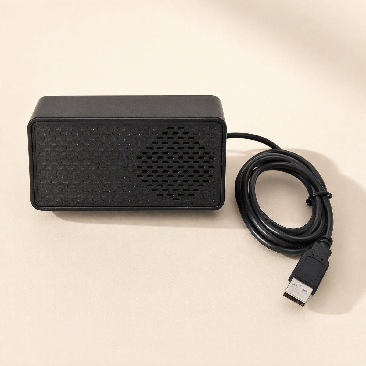 Soundport – Top-down view of the black speaker with its cable coiled beside it and the USB plug at the bottom