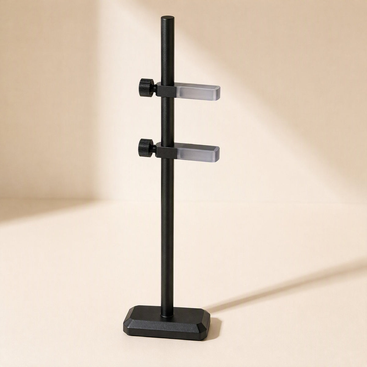 Chipbrace – Black bracket with two clamp arms and thumbscrews, frosted clear pads, in sunlit room corner