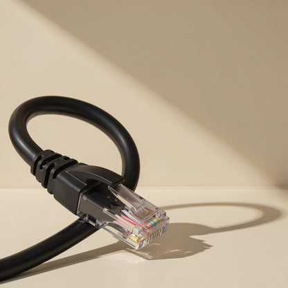 Twistcord Cat6 network cable in black looped upward, RJ-45 plug in foreground on a cream surface