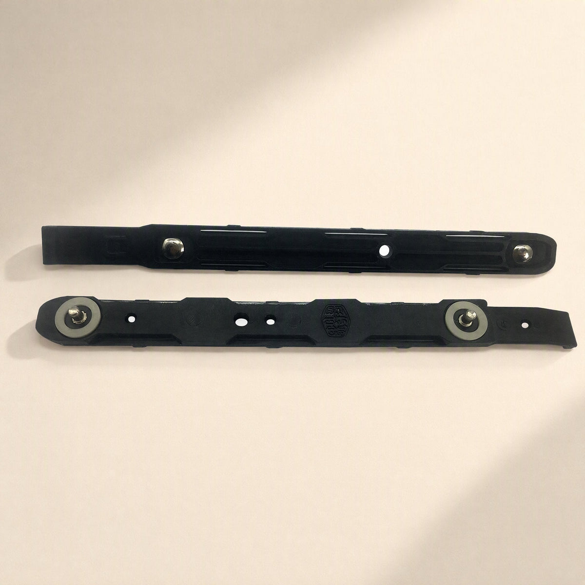 Coolbrace Hard Drive Bracket pair in black plastic with metal pins, laid flat on a cream background