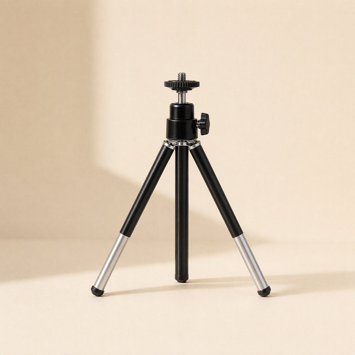 Phoneprop – Black tripod stand with silver lower leg sections extended, on a cream background with soft shadow