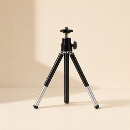 Phoneprop – Black tripod stand with silver lower leg sections extended, on a cream background with soft shadow