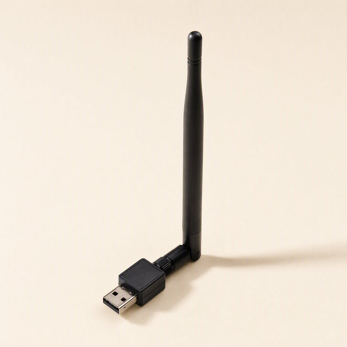 Netplug – Black USB wireless adapter with antenna angled up, seen from the front on a beige background