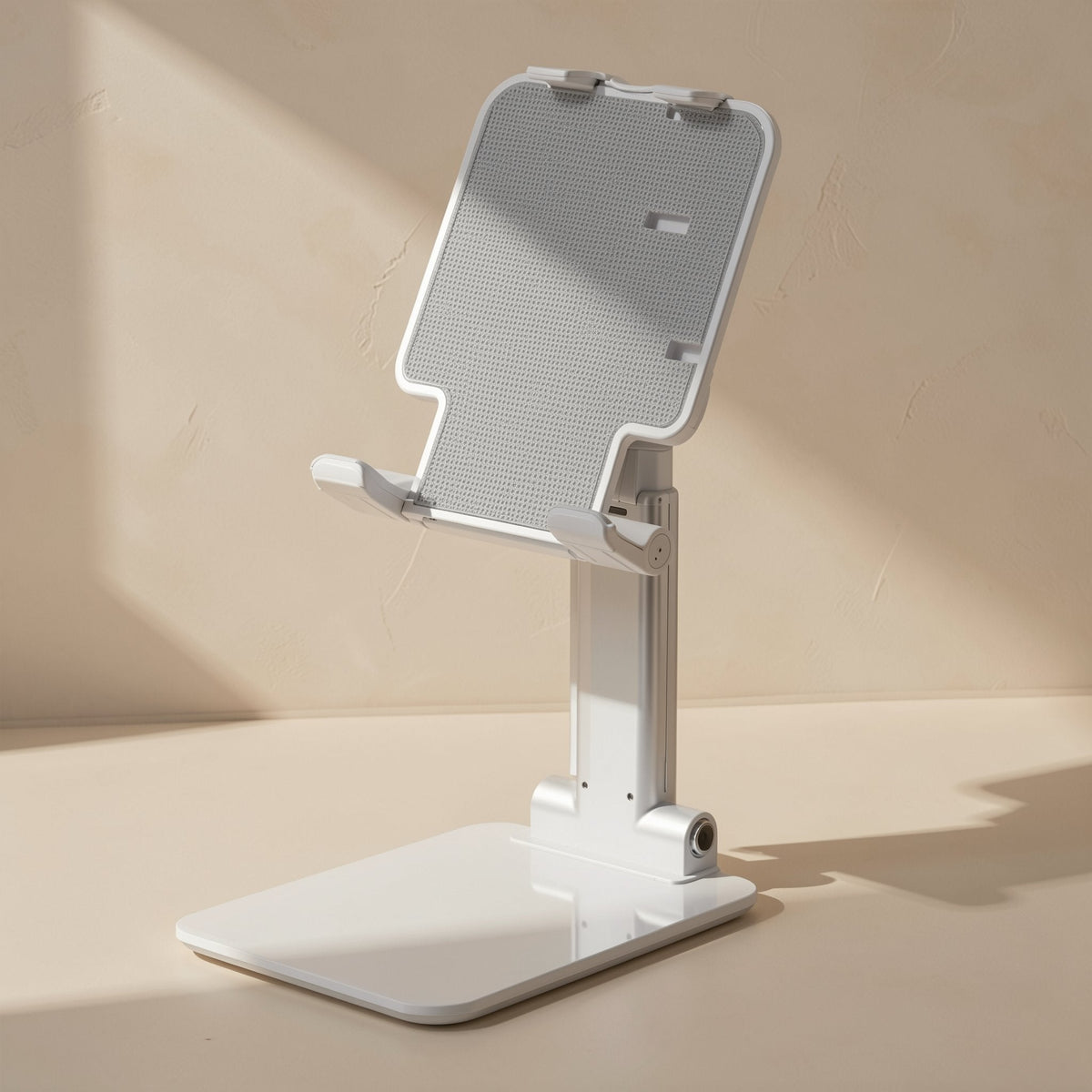 Deskease – Back view of the white holder with its textured grey panel and wide base on a beige surface