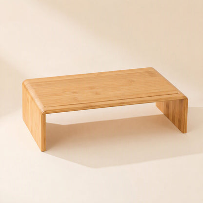 Bamboorise – Bamboo monitor riser with open sides and a smooth top, shown from a high front angle on a cream backdrop