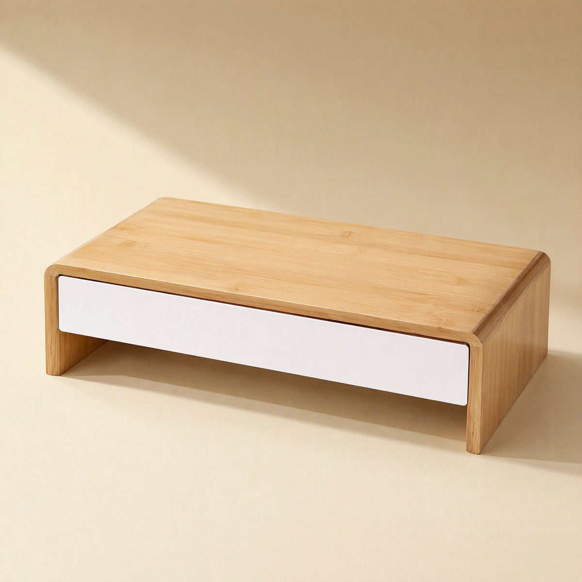 Bamboorise – Bamboo monitor stand with a single white front drawer, seen from a high three-quarter angle