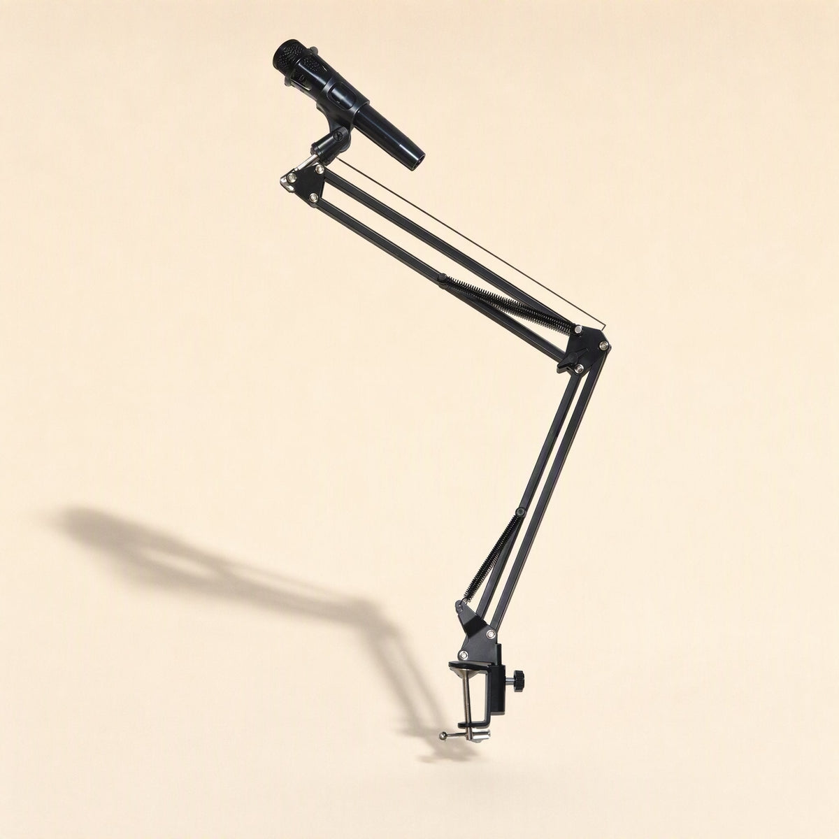 Deskarm – Black metal cantilever arm with microphone attached, angled upward with a long shadow behind
