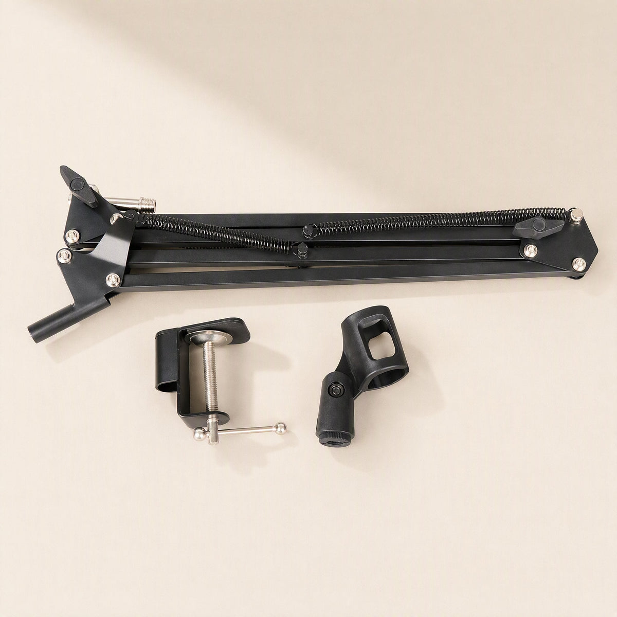 Deskarm – Disassembled arm folded flat beside the separate desk clamp and microphone holder