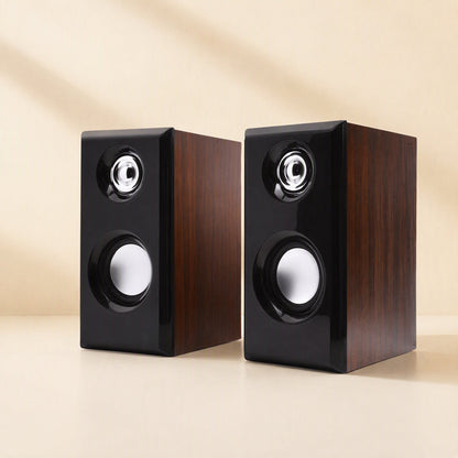 Woodtone – Angled view of two wood-grain speakers with black front panels, silver tweeters and round woofers