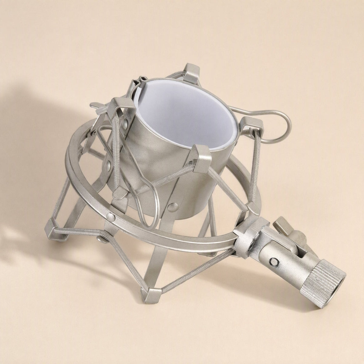 Micbuffer – Silver shock mount seen from above at an angle, showing the white inner cradle and threaded base