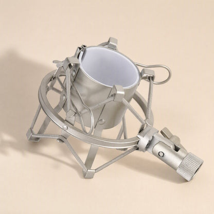 Micbuffer – Silver shock mount seen from above at an angle, showing the white inner cradle and threaded base