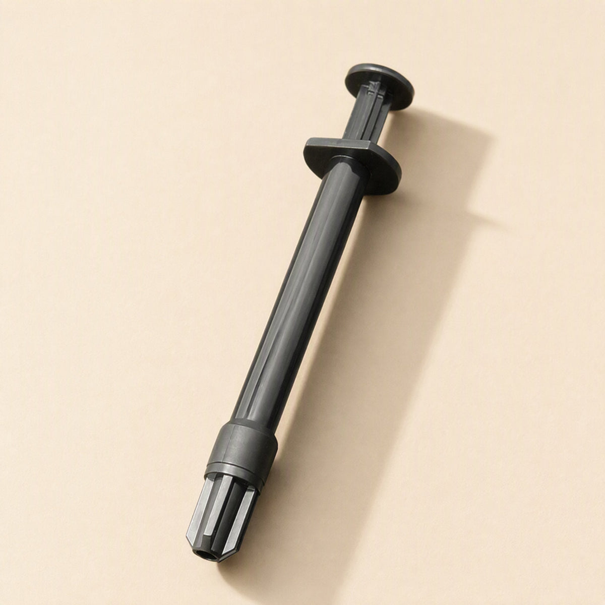 Meltlink Liquid Metal Thermal Paste in a black syringe, shown diagonally on a beige background
