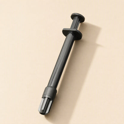 Meltlink Liquid Metal Thermal Paste in a black syringe, shown diagonally on a beige background