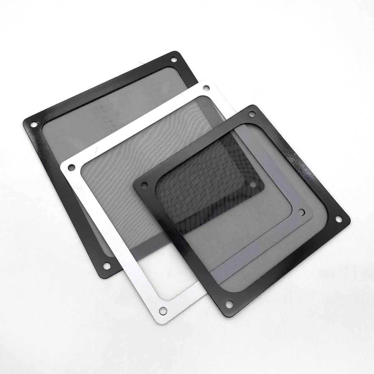 Ventmesh – Three dust filter nets in different sizes, black and white frames, arranged in an overlapping fan on white