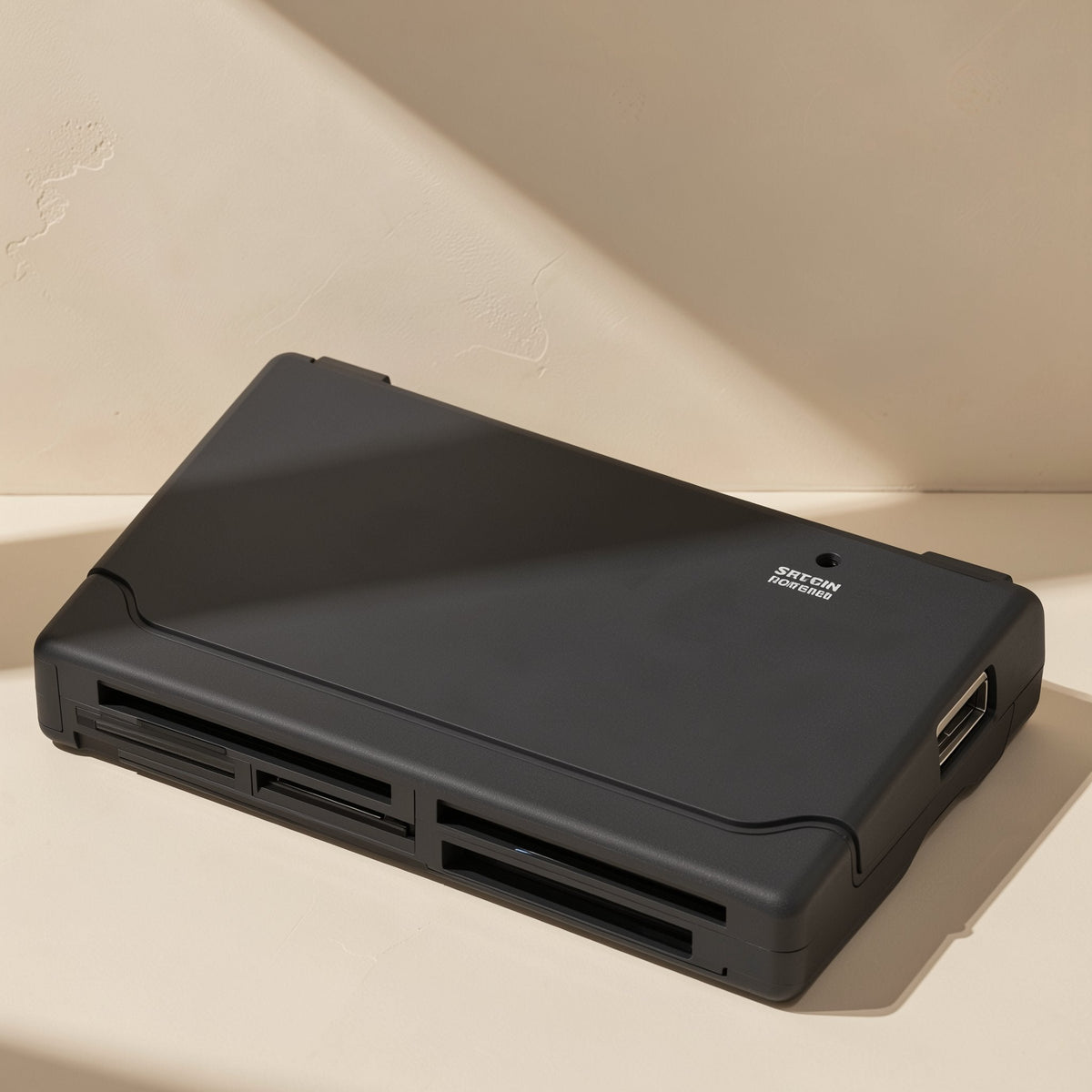 Chipplug USB memory card reader, black, angled top view with multiple card slots on a beige surface