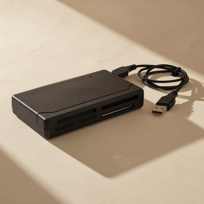Chipplug – Black multi-format card reader with attached USB cable coiled beside it, side view with slot openings