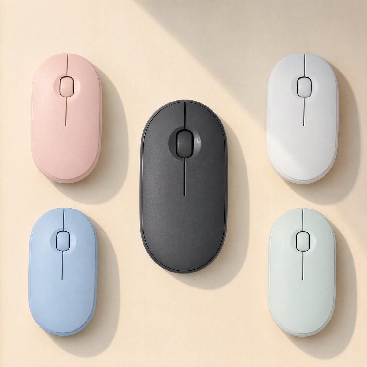 Quietcursor Wireless Bluetooth Silent Mouse in pink, white, black, blue and mint, seen from above on cream