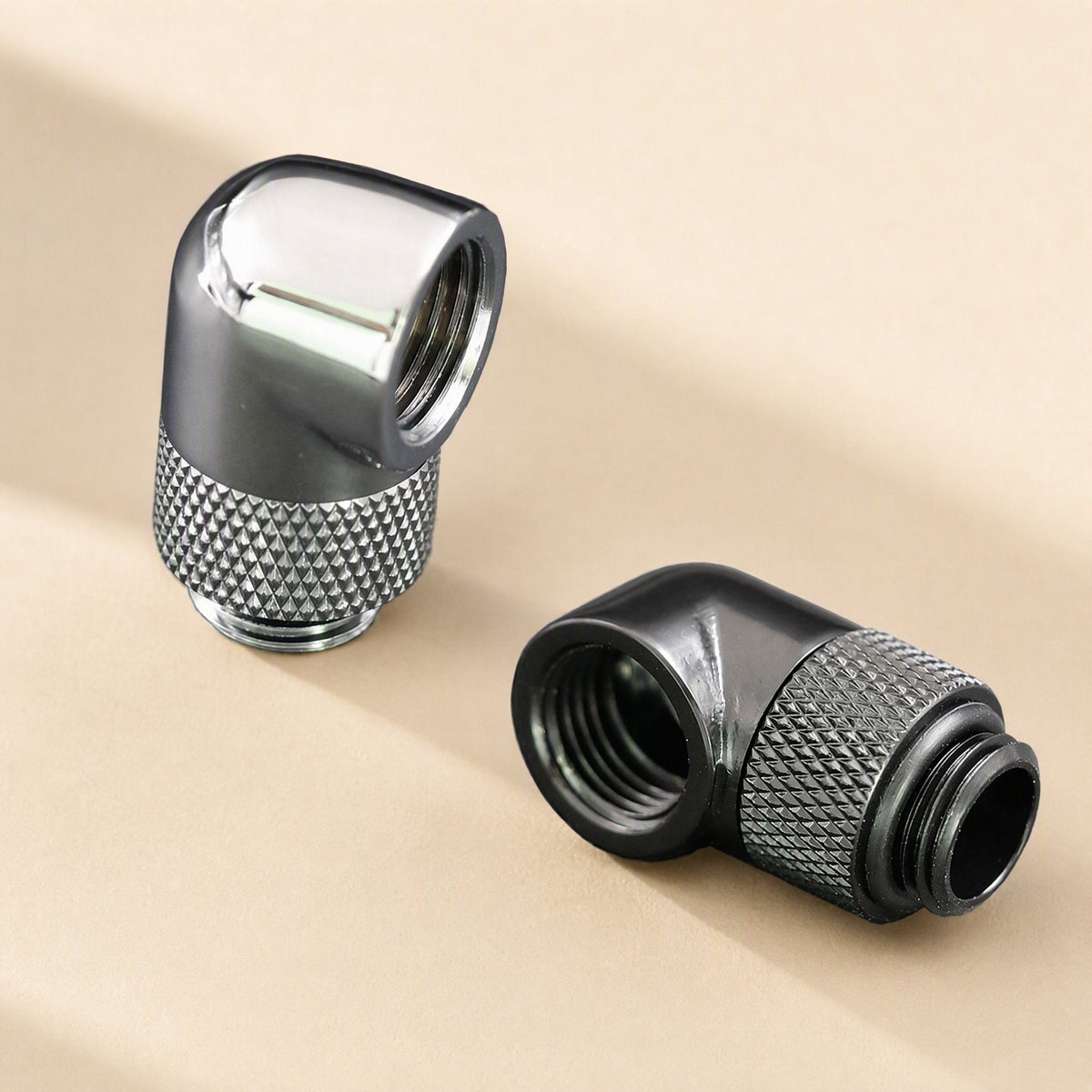 Swivelbend – Chrome and black G1/4 elbow fittings side by side, showing knurled grip rings and threaded openings