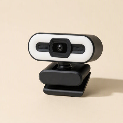 Quickfocus – Side-angled view of the black clip-on webcam with lit ring light, centered lens and flat base