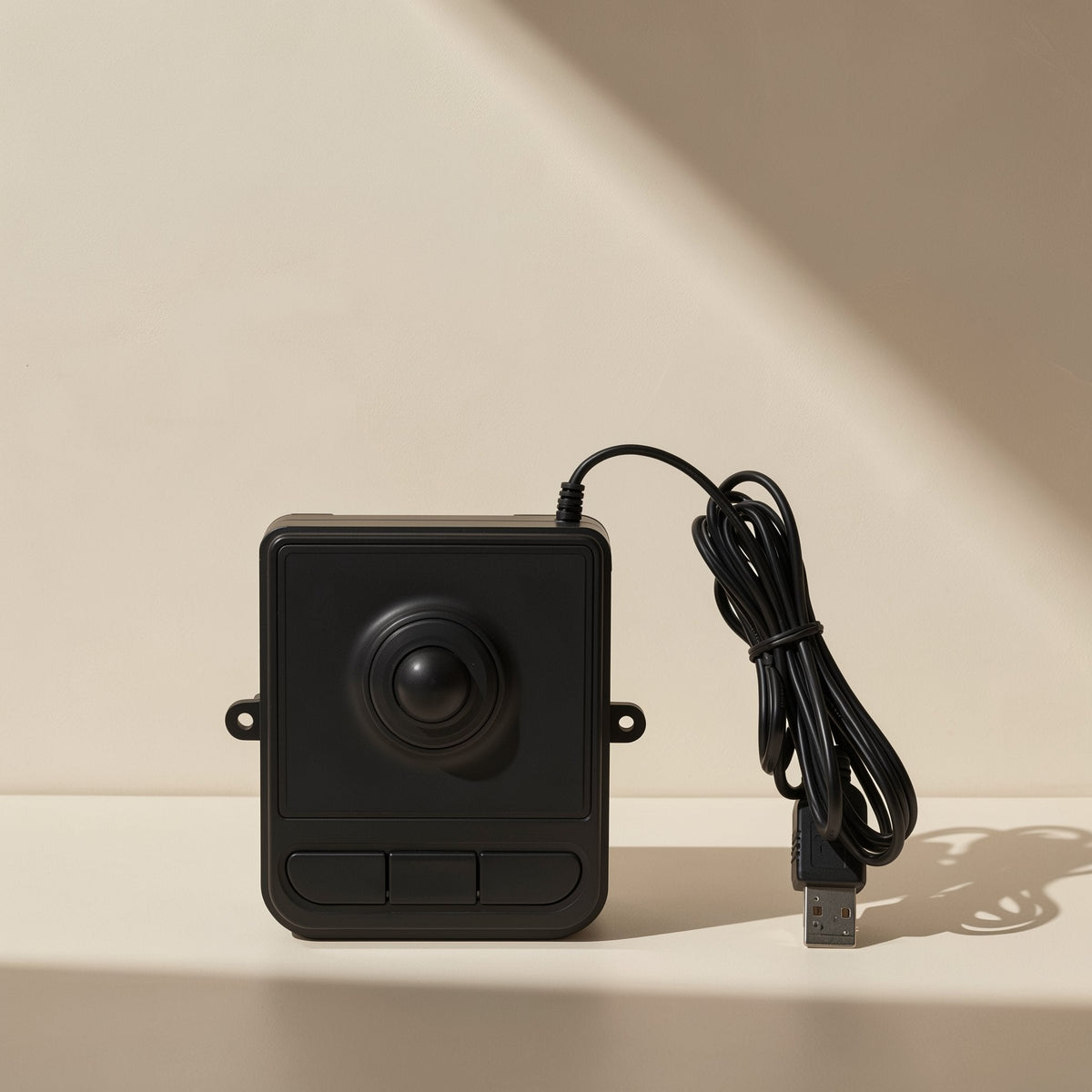Trackroll – Black trackball mouse with coiled USB cable, front view showing ball, buttons and side mounting tabs