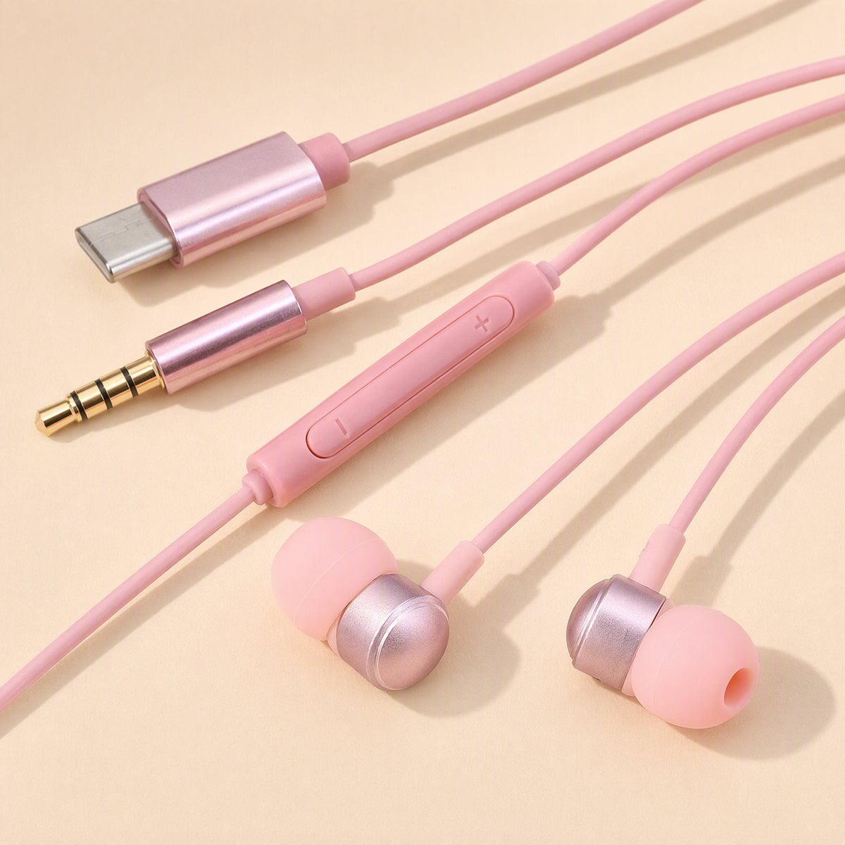 Earchime – Pink wired earbuds with inline volume remote, Type-C connector and 3.5mm plug laid on a cream background