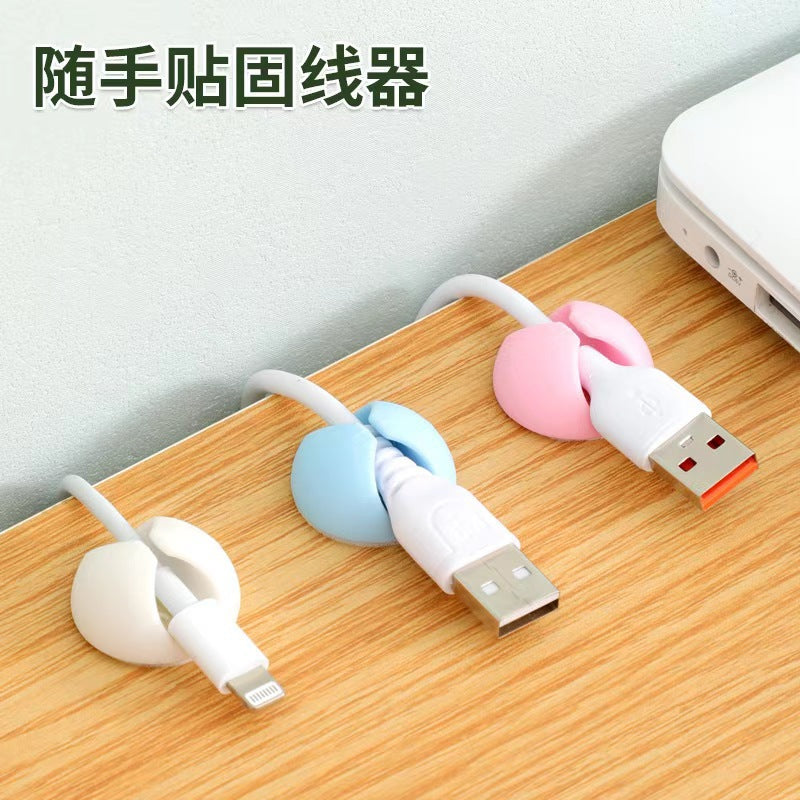 Cordscape – Pastel white, blue and pink clips on a desk holding Lightning and USB cables near a laptop, with Chinese text