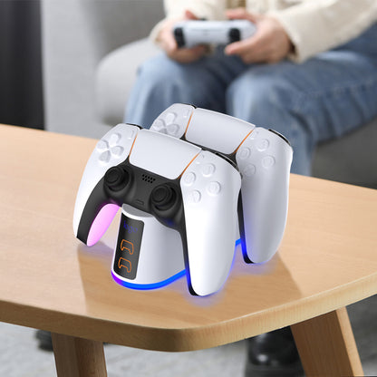 Arcglow – Charging stand with two controllers and glowing base on a wooden table, a person holding a controller on a sofa