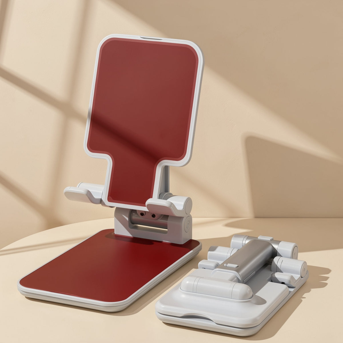 Foldperch Foldable Adjustable Phone Stand in red and white, open beside a second stand folded flat