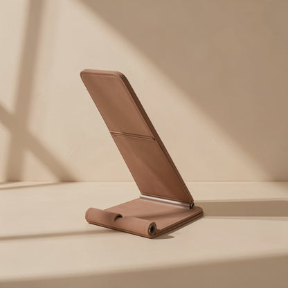 Foldperch – Tan leather-look phone stand folded at an angle on a beige surface in soft window light