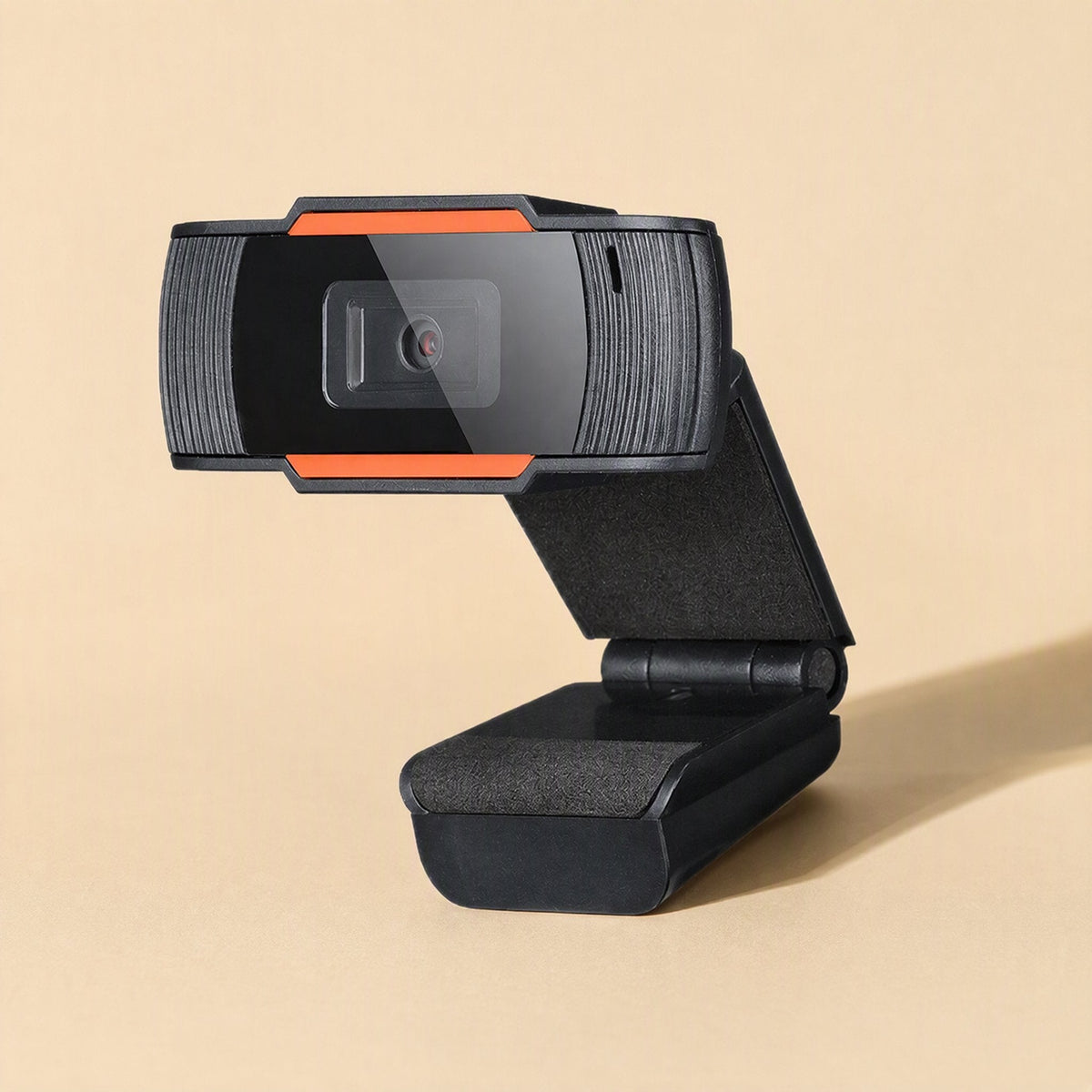 Clearcam – Side angle of the webcam on its padded clip stand, with the hinge and orange-trimmed front visible