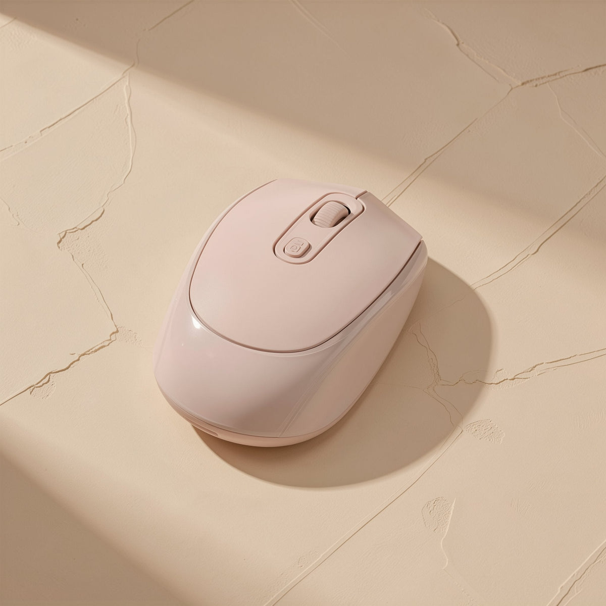 Opticlick Wireless Bluetooth Optical Mouse in blush pink on a cracked beige plaster surface, seen from above