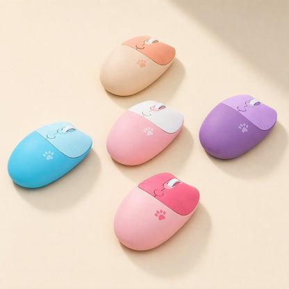 Triclick – Five cat-ear wireless mice in orange, pink, purple, blue and rose, each with a paw print, on a beige surface